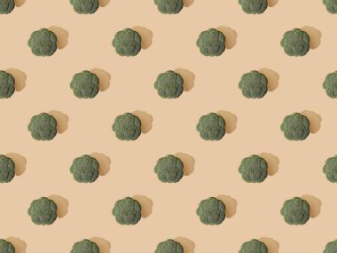 Bej arka planda taze yeşil brokoli üst görünümü, pürüzsüz desen