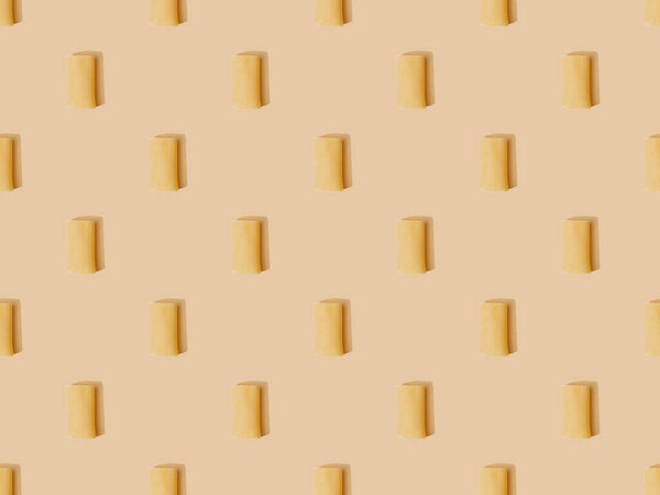 вид сверху на свежие каннеллони на бежевом фоне, бесшовный узор
