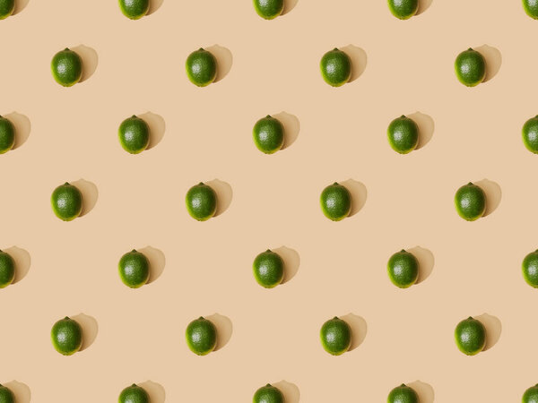 top view of fresh whole limes on beige background, seamless pattern