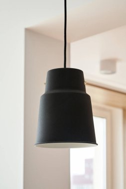 black lamp hanging near white walls in apartment  clipart