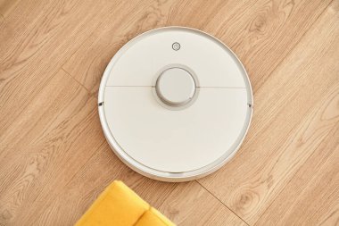 Beyaz robotik elektrik süpürgesinin yer temizleme görüntüsü 