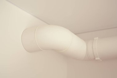 water pipe near white walls and ceiling in apartment  clipart