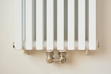 white and modern heating radiator near wall in apartment  clipart