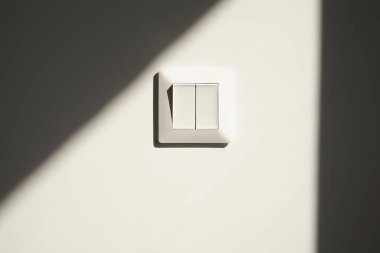 Beyaz düğmedeki güneş ışığı Dairedeki duvarda 