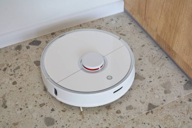 Modern robot süpürge dairede yer döşemelerini yıkıyor. 