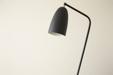 Beyaz duvara yaslanmış siyah modern lamba