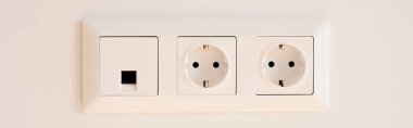 panoramic orientation of switch near power sockets on white  clipart