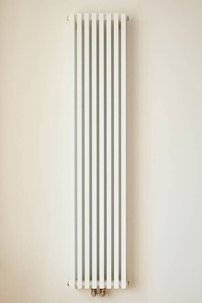 white heating radiator near wall in apartment 