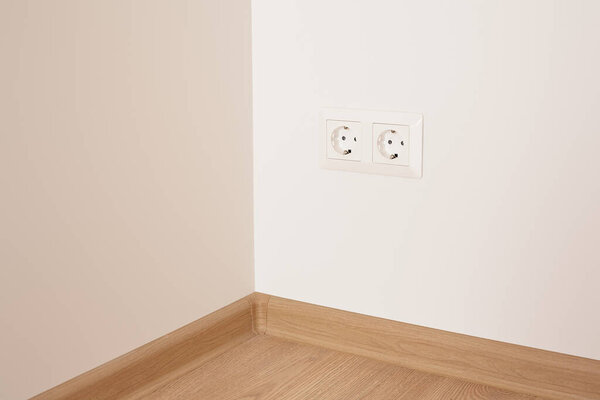 modern power plugs on white wall in apartment 