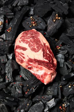 Siyah kömürlü taze bifteğin biberli üst görüntüsü.