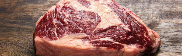 fresh raw steak on wooden cutting board, panoramic shot