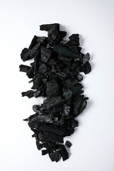 top view of black coals on white background