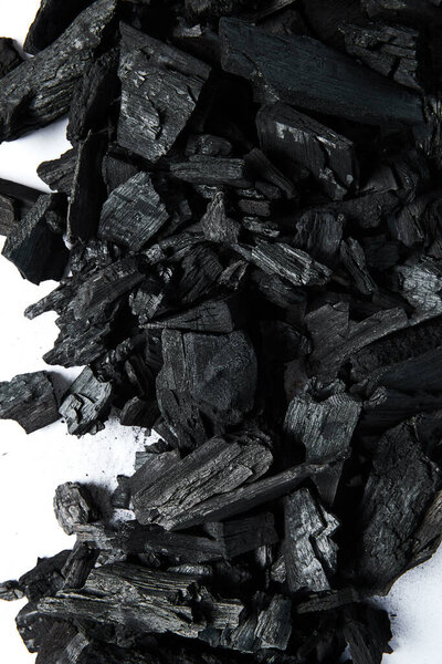 top view of black coals on white background