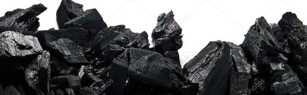 top view of black coals on white background, panoramic shot