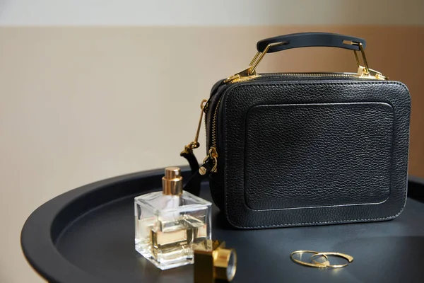 Bolso Cuero Cerca Pendientes Oro Perfume Sobre Mesa Negra Sobre —  Fotos de Stock