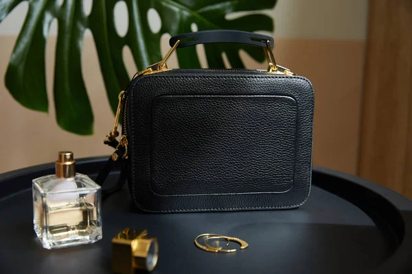 Leather Handbag Golden Earrings Perfume Black Table Tropical Leaf — Stock Photo, Image