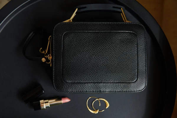 Altın Küpelerin Yanındaki Deri Çantanın Üst Görüntüsü Siyah Masanın Üzerindeki — Stok fotoğraf