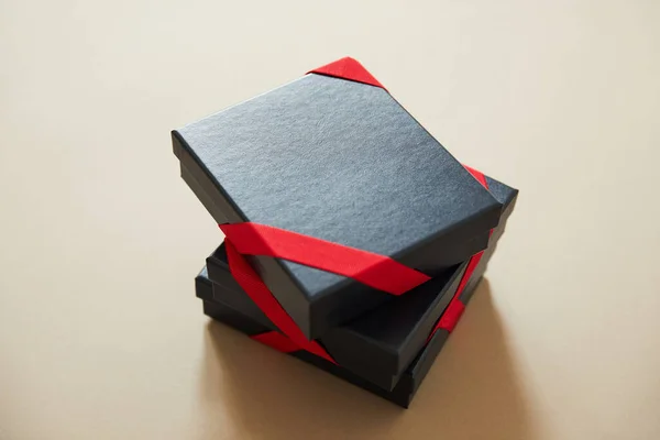 Μαύρα Κουτιά Δώρου Κόκκινες Κορδέλες Μπεζ Φόντο — Φωτογραφία Αρχείου