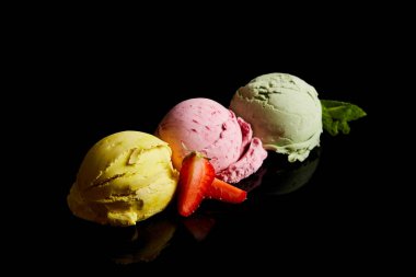 delicious lemon, strawberry and mint ice cream balls isolated on black clipart