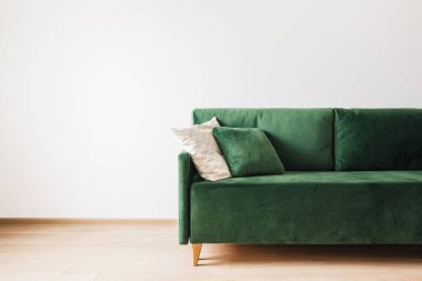 Geniş odada yastıklı modern yeşil kanepe.