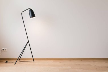 metal modern floor lamp near grey wall clipart