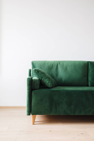 close up view of modern green sofa with pillow in room