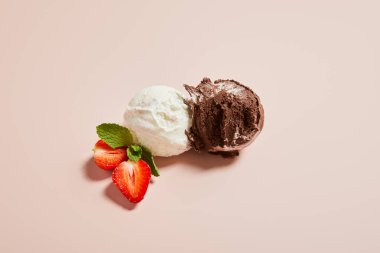 Taze beyaz ve çikolatalı dondurma toplarının üst görüntüsü. Pembe arka planda naneli ve çilekli.