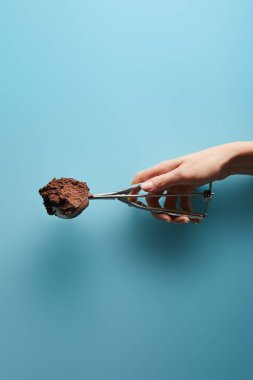 Mavi arka planda çikolatalı dondurmayla kepçe taşıyan kadın manzarası.