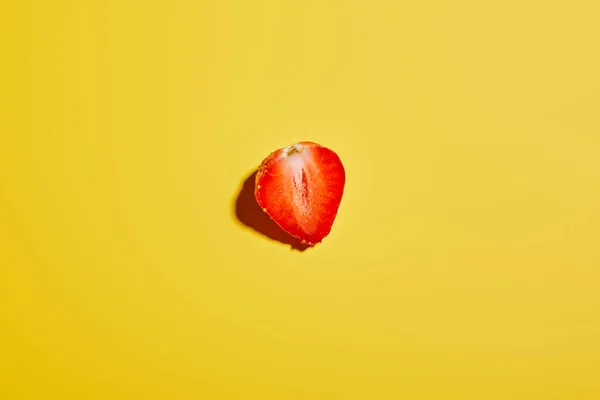 top view of fresh tasty strawberry half on yellow background