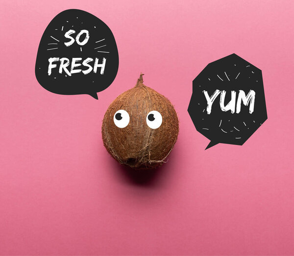 top view of whole coconut with illustrated eyes on pink background with so fresh and yum lettering in black speech bubbles