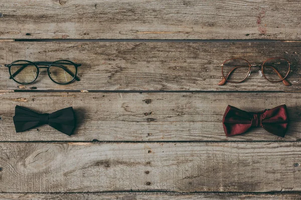 Stylish bow ties and eyeglasses on tabletop — Stock Photo