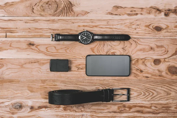 Smartphone con correa y relojes de mano en la mesa - foto de stock