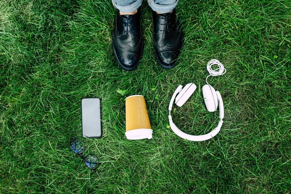 Appareils numériques et tasse en papier sur herbe — Photo de stock