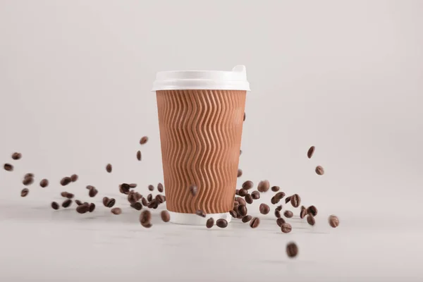 Одноразова чашка з кавовими зернами — стокове фото