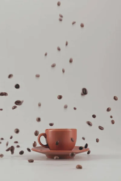 Tasse de café avec grains de café tombant — Photo de stock