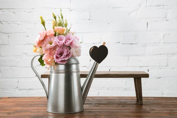 Beautiful flowers in watering can — Stock Photo