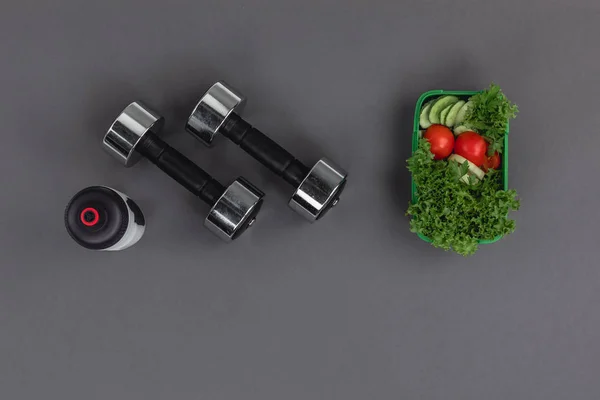 Dumbbells with sports bottle and salad — Stock Photo