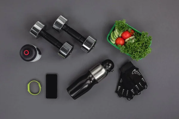 Halteres com salada de legumes e gadgets — Fotografia de Stock