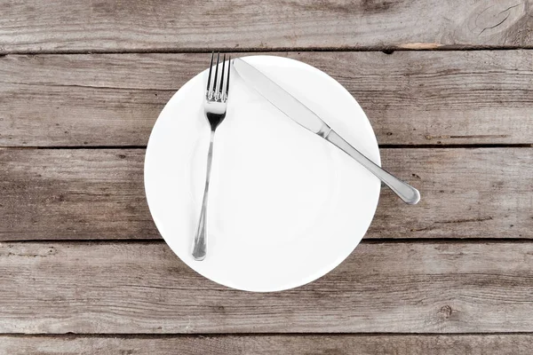 Empty plate and silverware on table — Stock Photo