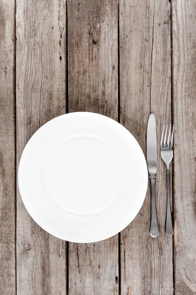 Empty plate and silverware on table — Stock Photo