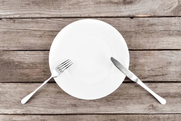 Empty plate and silverware on table — Stock Photo