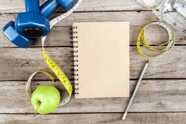 Notebook, apple and sport equipment — Stock Photo