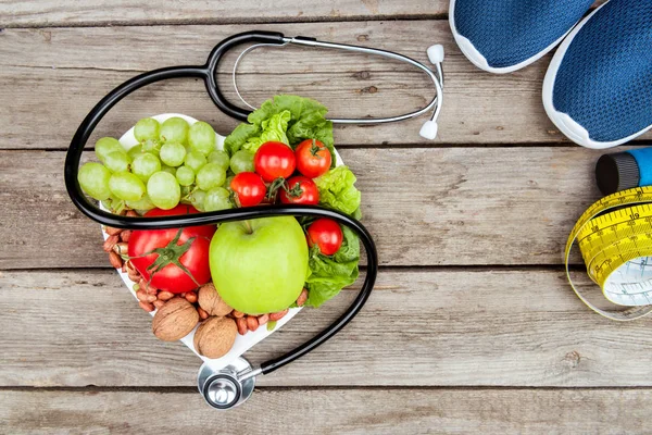 Stethoscope, organic food and sport equipment — Stock Photo