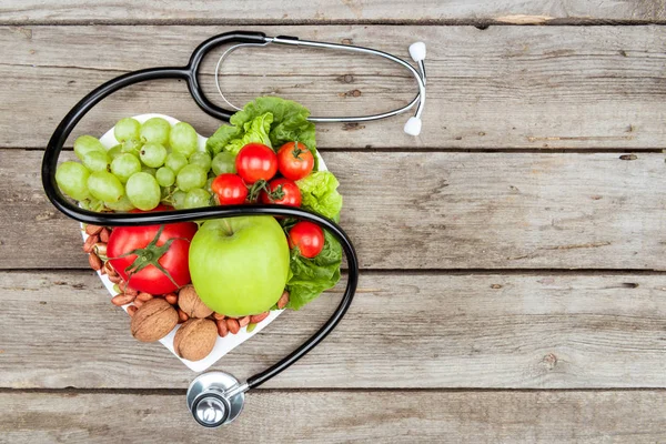 Stéthoscope, légumes et fruits biologiques — Photo de stock