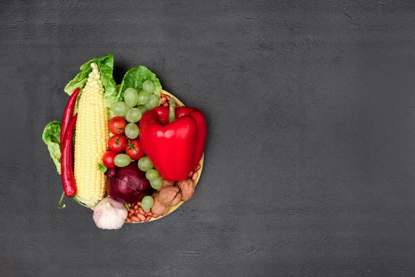 Organic vegetables and fruits on plate — Stock Photo