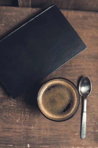 Un vaso de café, libro viejo - foto de stock