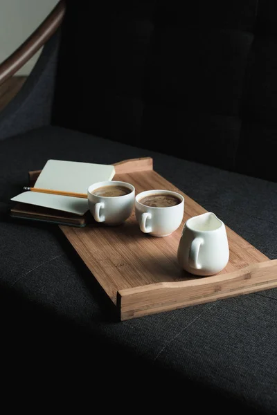 Caffè, brocca di latte e taccuino su vassoio — Foto stock