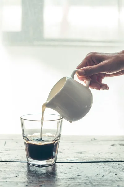 Verser le lait dans le café — Photo de stock