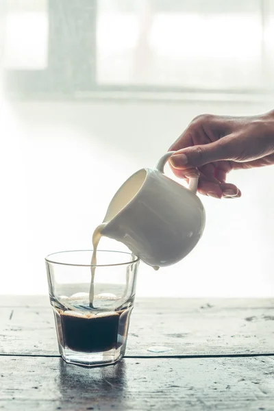 Milch in Kaffee gießen — Stockfoto