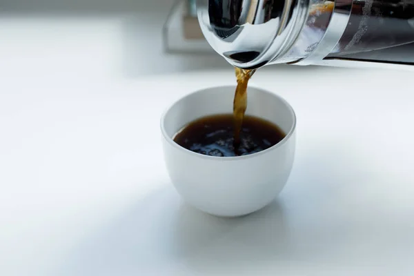 Person gießt schwarzen Kaffee ein — Stockfoto